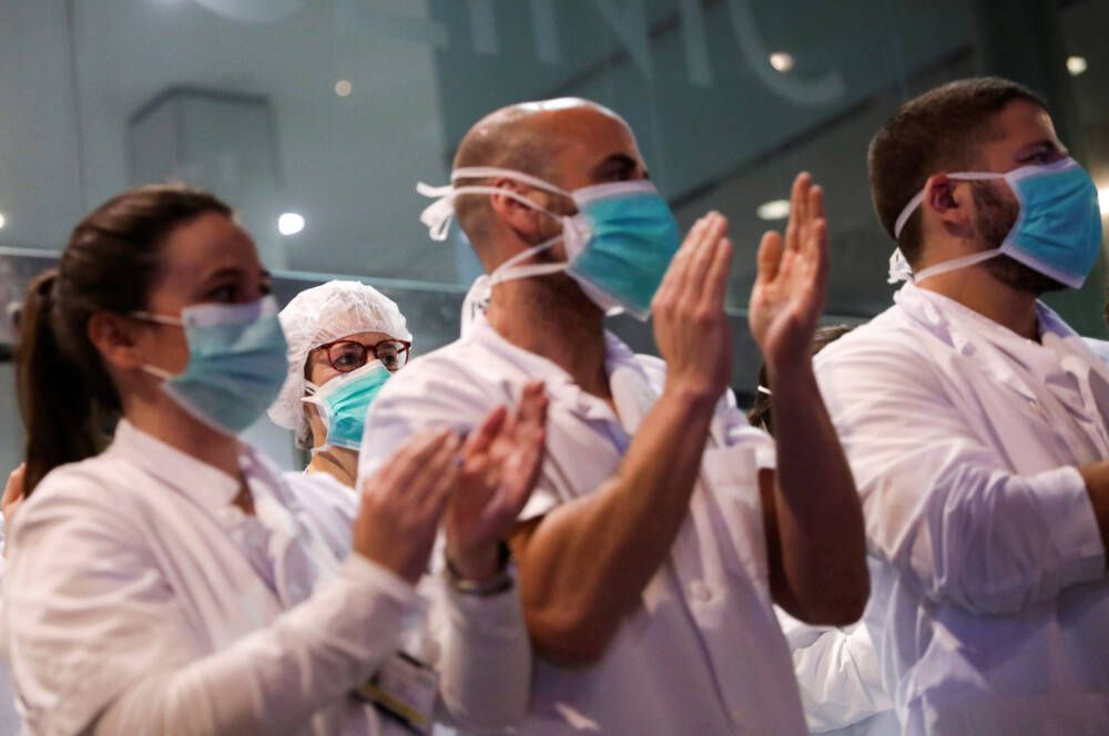 Health workers from Clinic hospital applaud citizens who show them gratitude from their balconies and windows, during the coronavirus disease (COVID-19) outbreak, in Barcelona