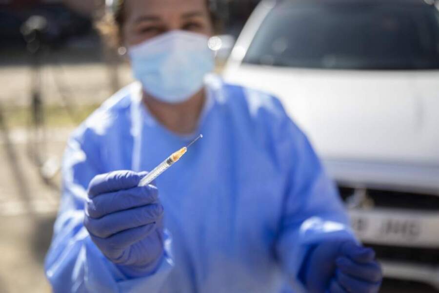 Sanitaria enseñando vacuna