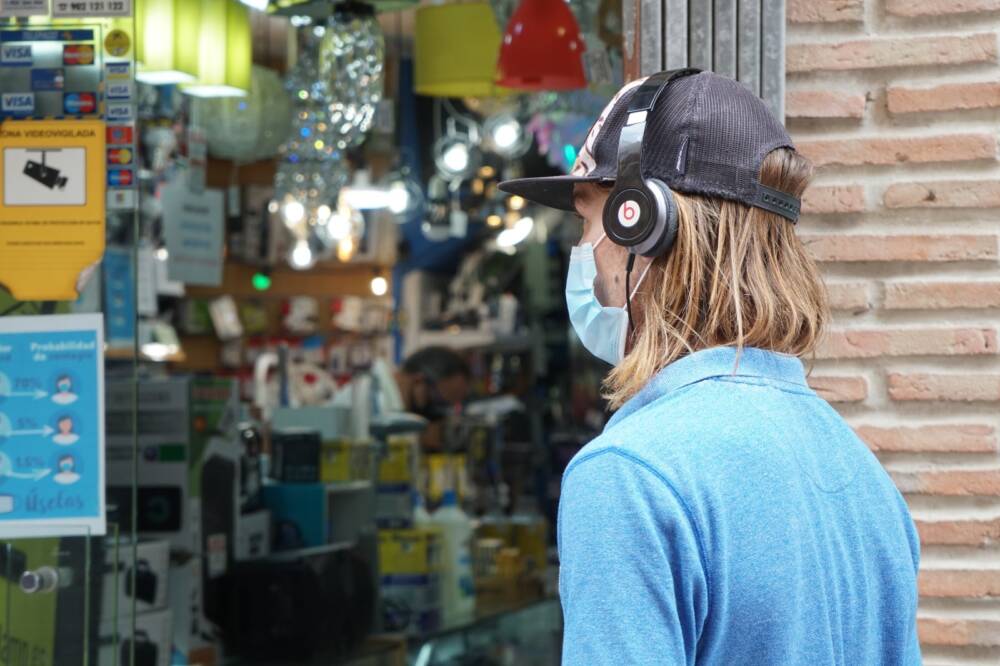 Repunte del Covid-19 y gripe: Sanidad recomienda el uso de mascarillas y la higiene de manos. Joven con mascarilla en La Línea.