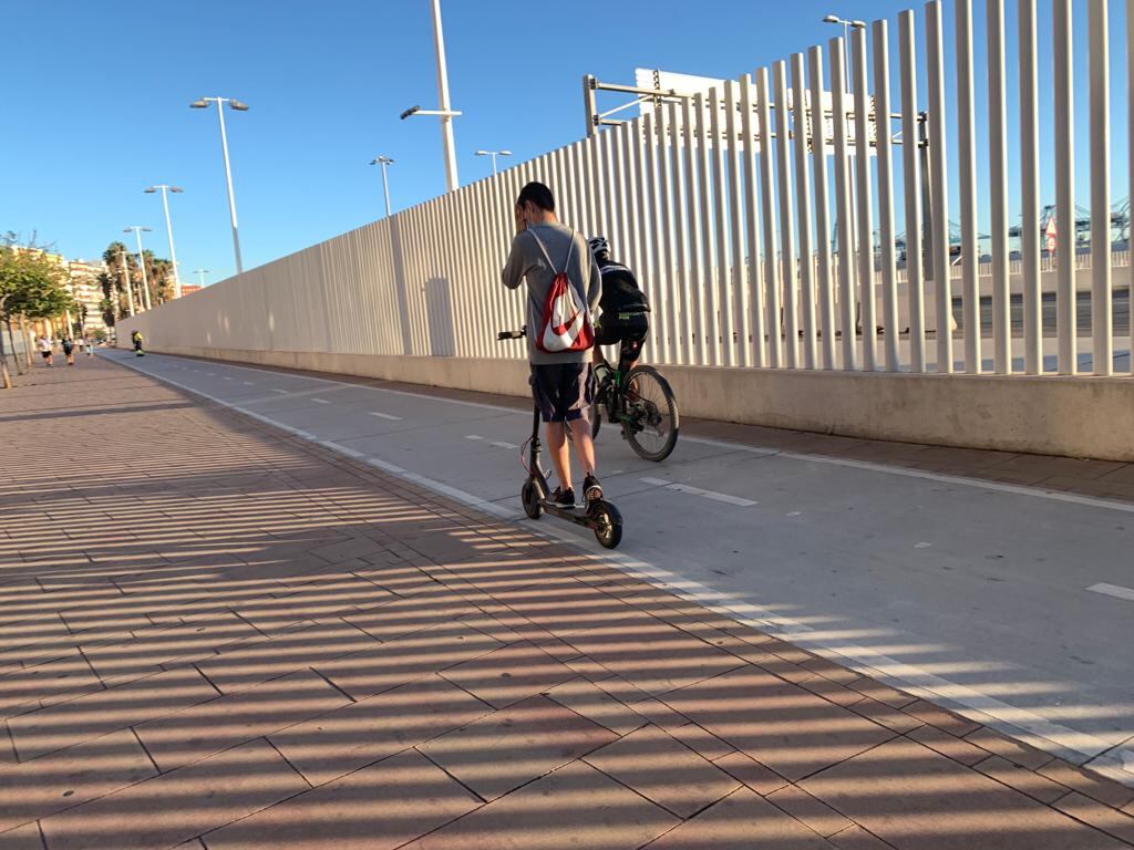 Patín y bicicleta por un carril bici.