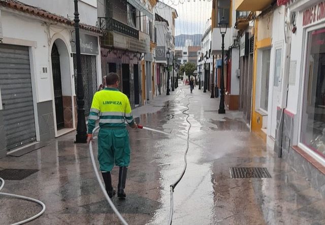 Un operario limpia la calle La Plata.
