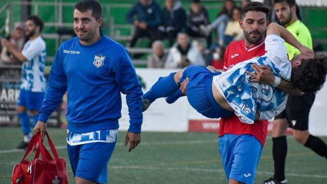 El guadiareño Keke saca en brazos a Fran Rodríguez, jugador del CD Villamartín tras la lesión de éste