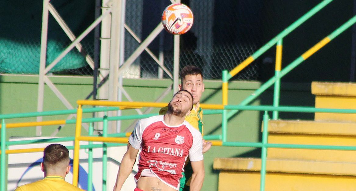 Bermu, jugador de la UD Los Barrios, salta con un futbolista de la UD Algaida (de rojo)