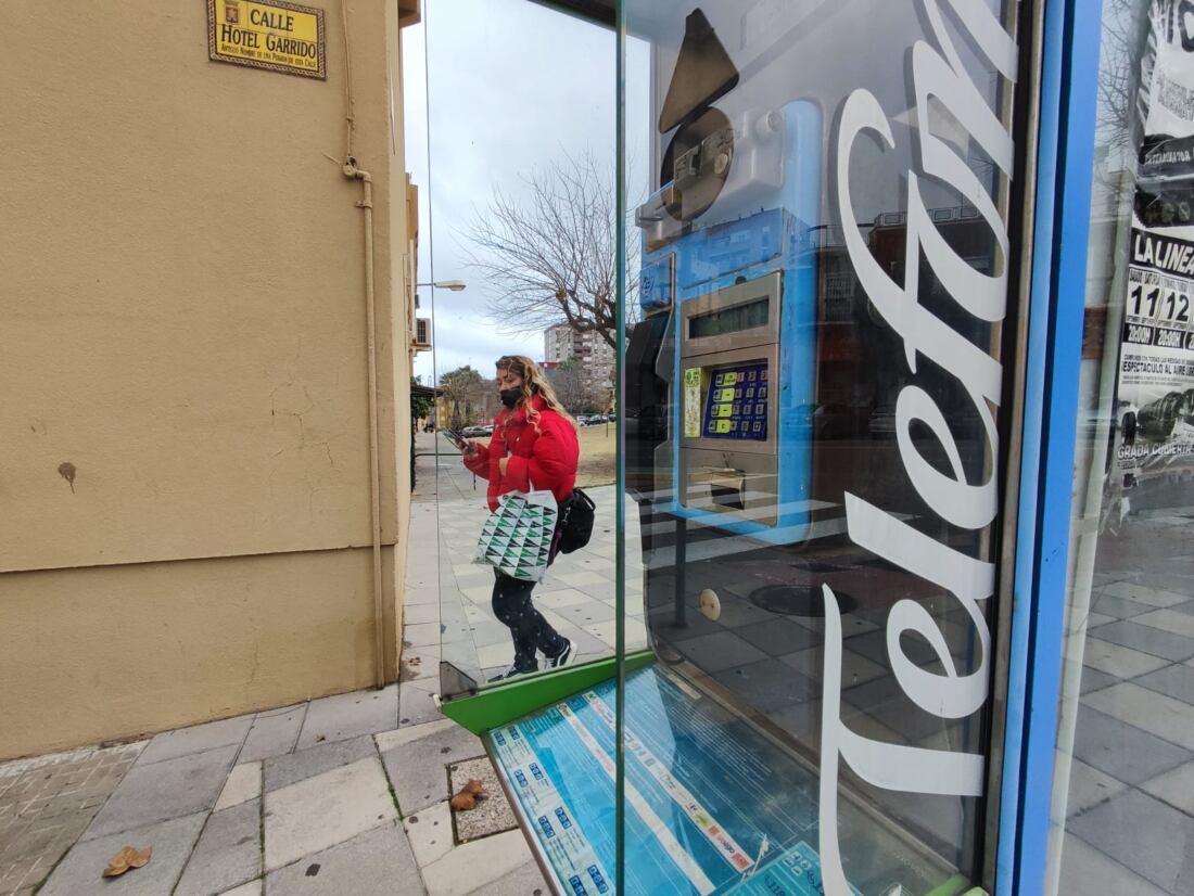 Una mujer por la cabina de teléfono usando el móvil. Fotos: Fran Montes.