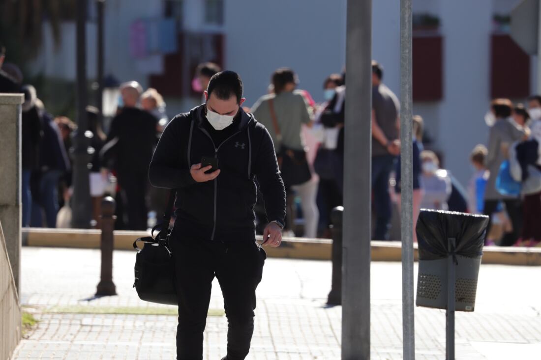 Un hombre mira su teléfono caminando por la calle. foto: Fran Montes.