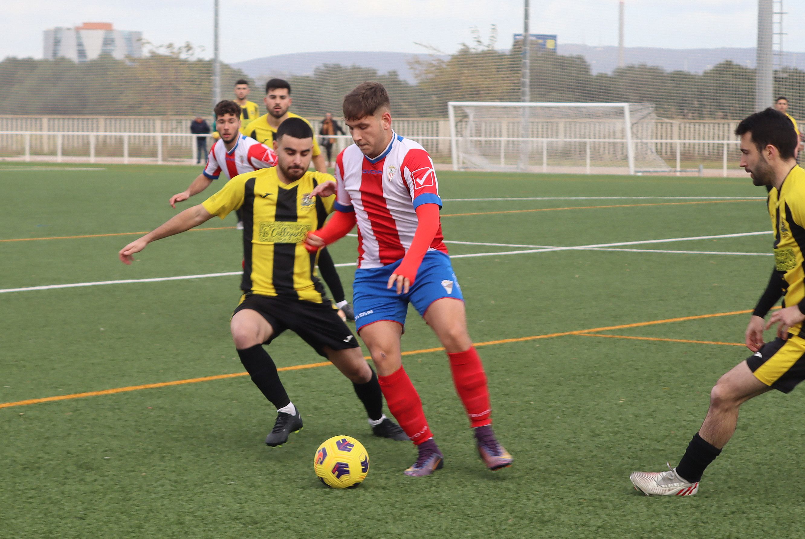 El jugador del Algeciras CF B, Felipe, trata de dar un pase ante dos jugadores del GE Bazán/Foto. Axel S.C.