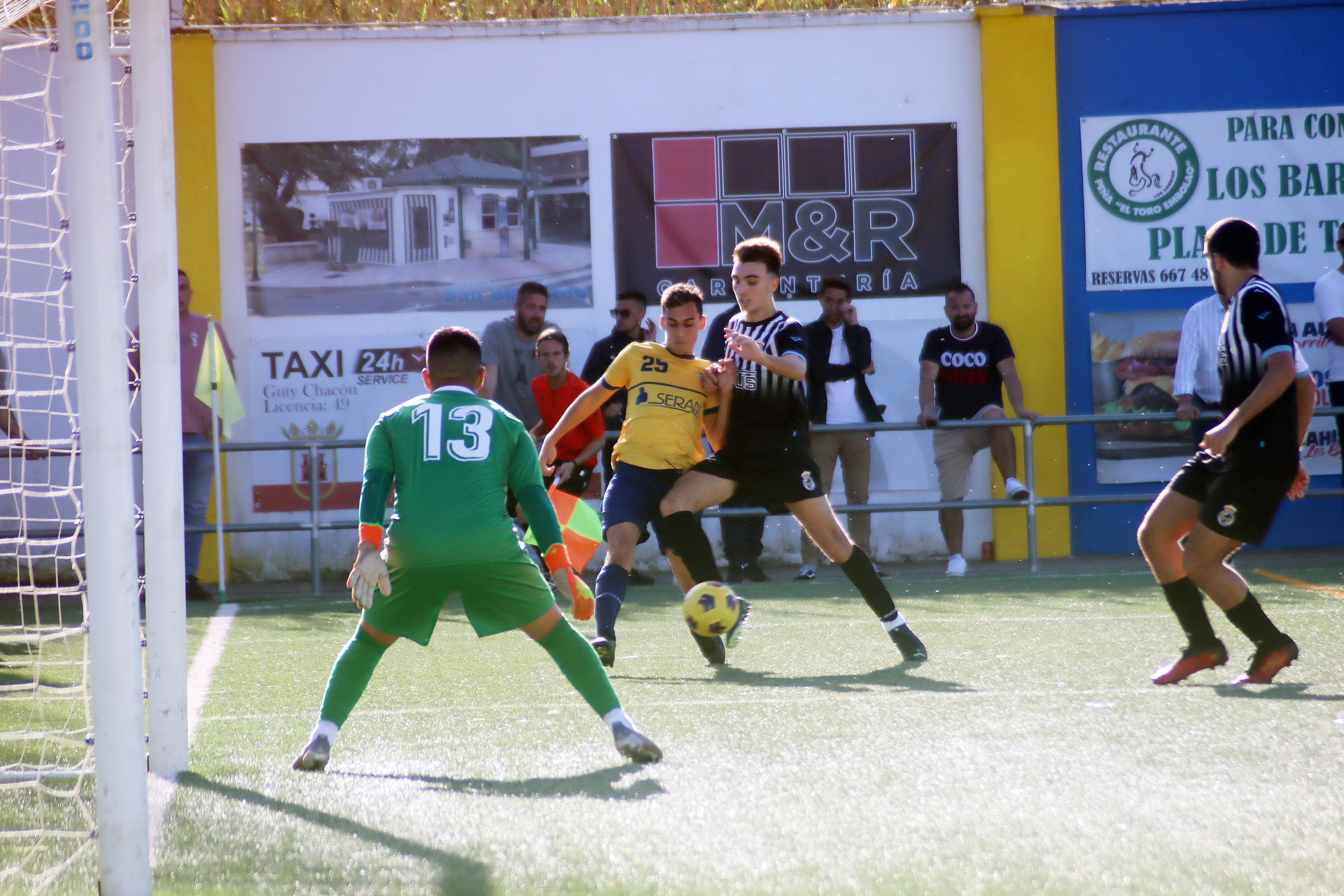 El jugador del CD San Bernardo, Juanma Ocaña, trata de marcharse de Adrián Jiménez, del filial de la RB Linense, ante la mirada del meta Diego Mercado