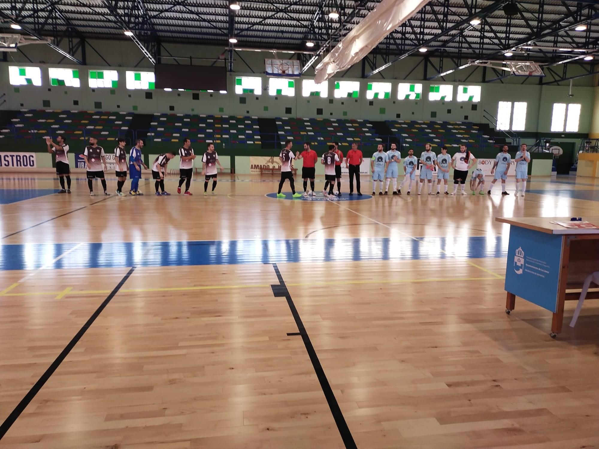 Los jugadores del CD LyU y el Portuense se saludan antes del comienzo del choque