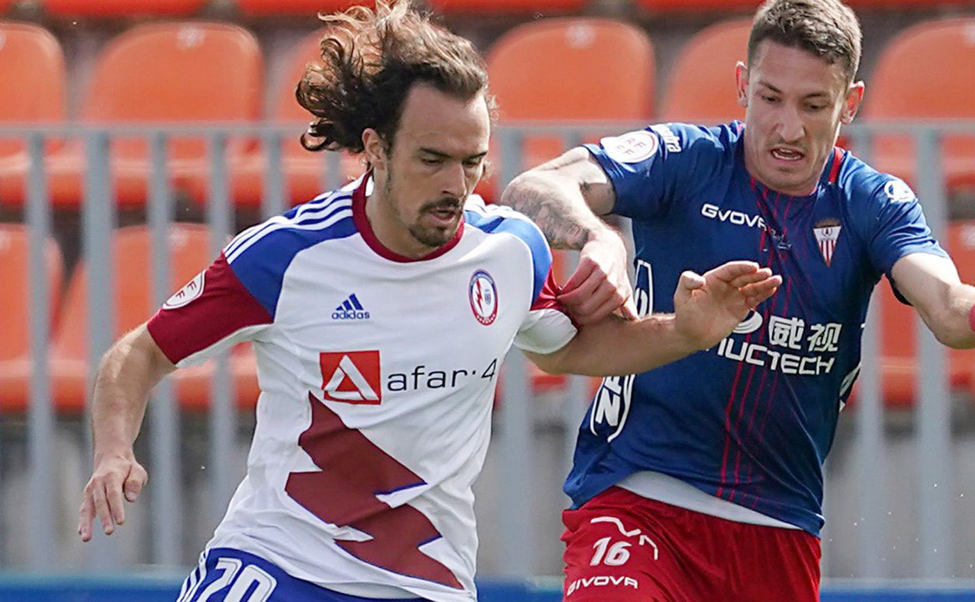 El jugador del Rayo Majadahonda, Pelayo Suárez, pugna con Elejalde, del Algeciras CF, en un lance del partido/Foto: @RMajadahonda