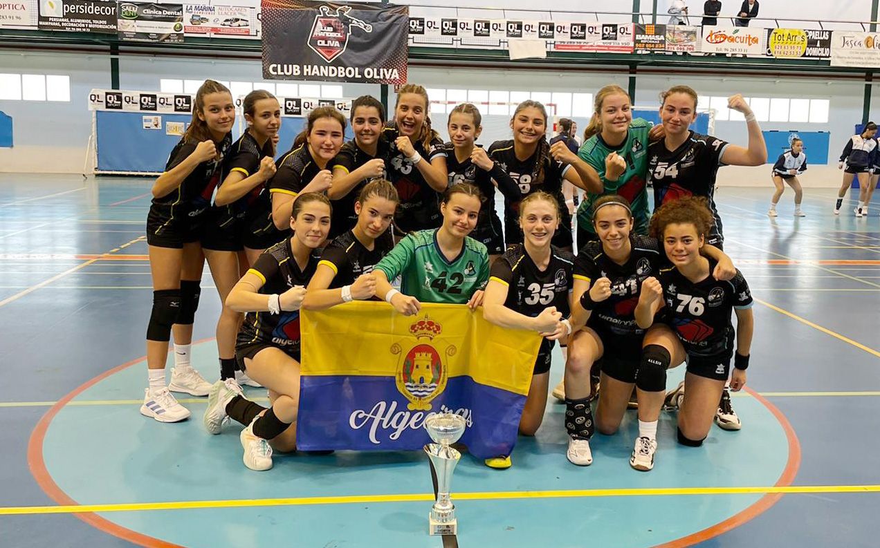 El equipo cadete femenino del BM Ciudad de Algeciras posa con la bandera de la ciudad y el trofeo de subcampeonas en Gandía