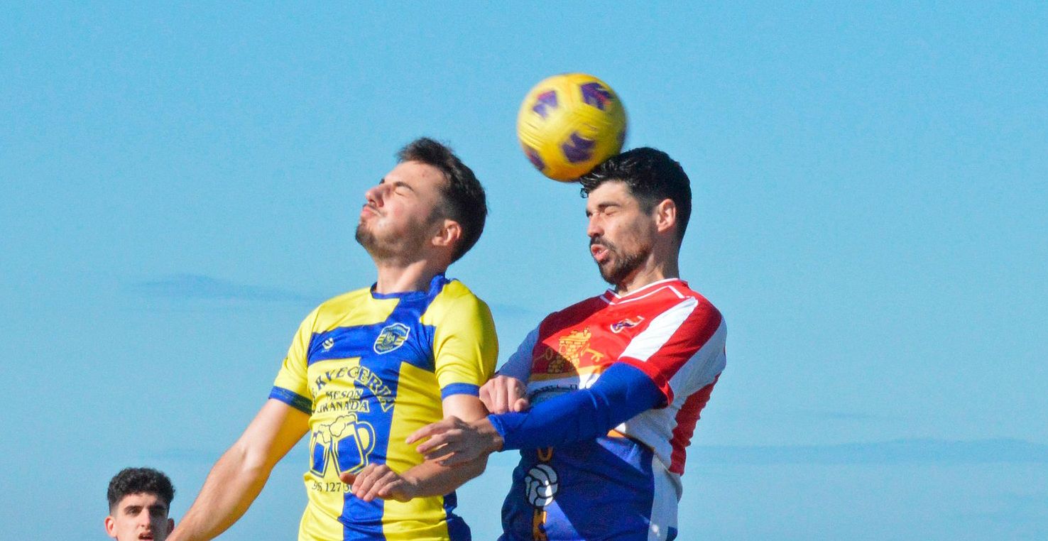 Juanma Quintero, de la UD Tarifa, salta con un futbolista del Atlético Puerto Serrano