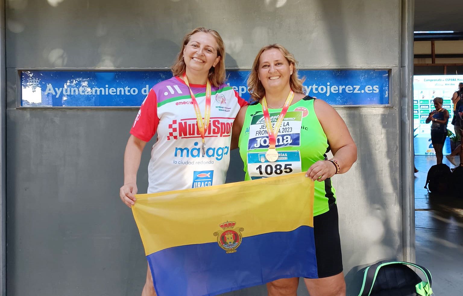 María José 'Koke' Hidalgo (i) y María Teresa Boza posan con sus medallas y la bandera de Algeciras