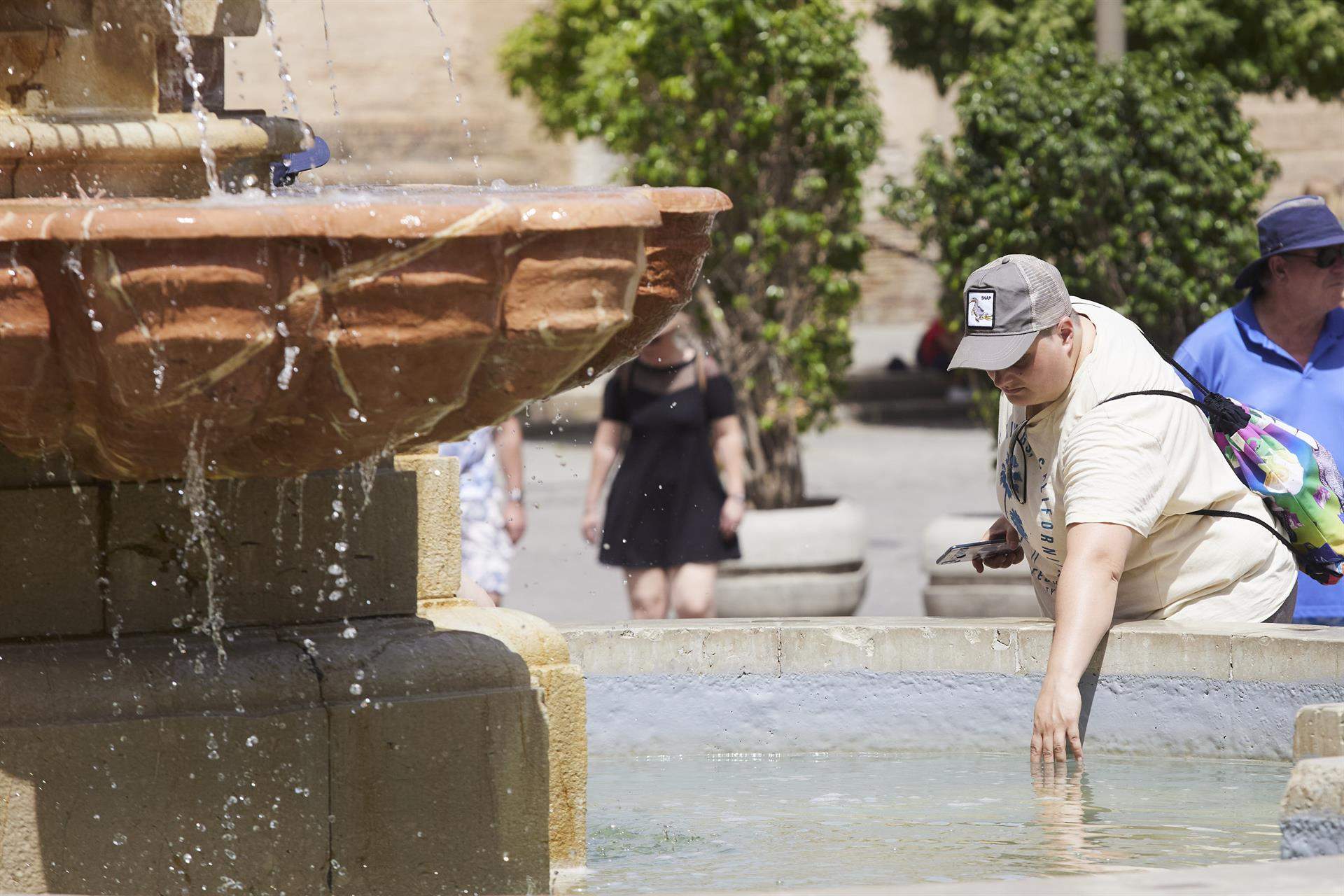 Un señor introduce la mano en una fuente para refrescarse. Imagen de archivo. - Joaquin Corchero - Europa Press - Archivo. 