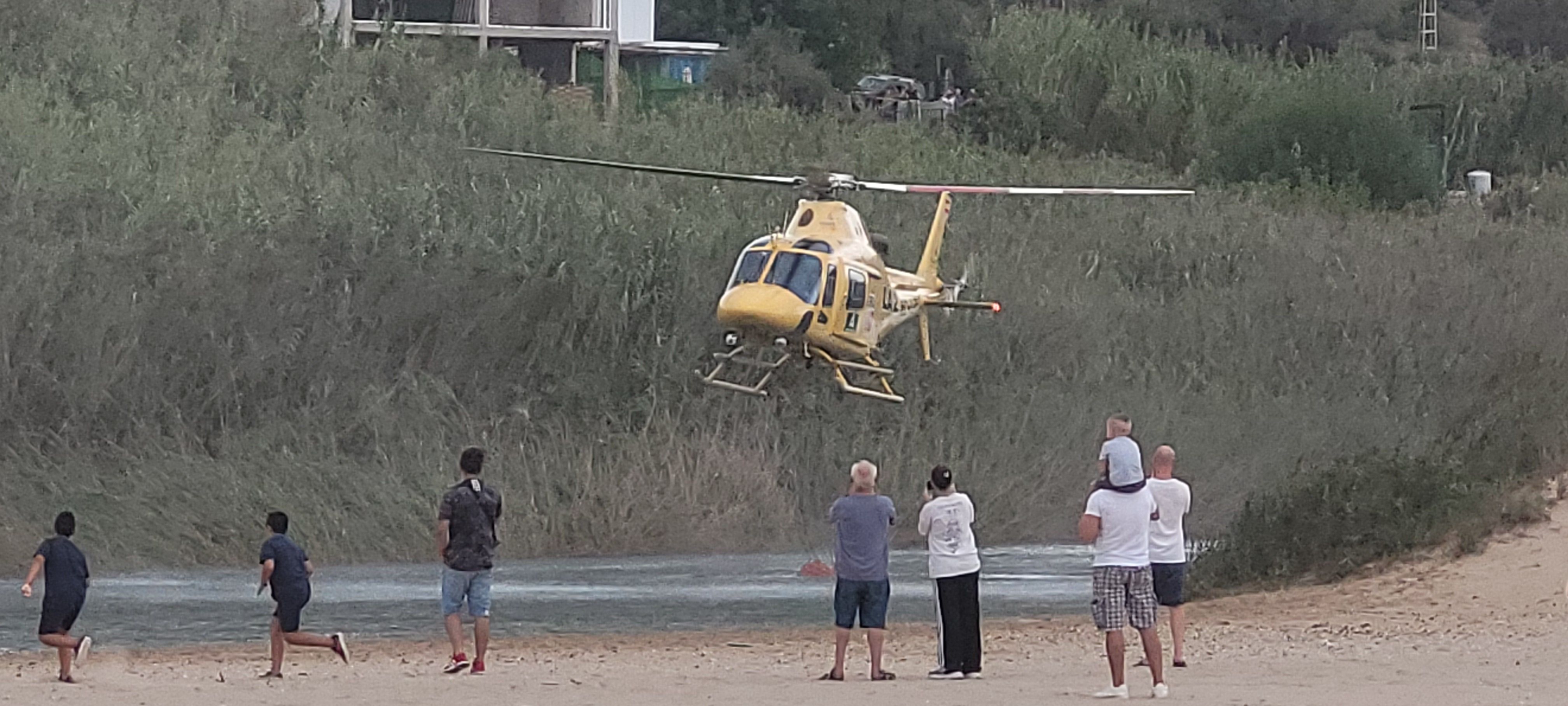 La recogida de agua del helicóptero del Infoca, la 'atracción' dominical en Getares