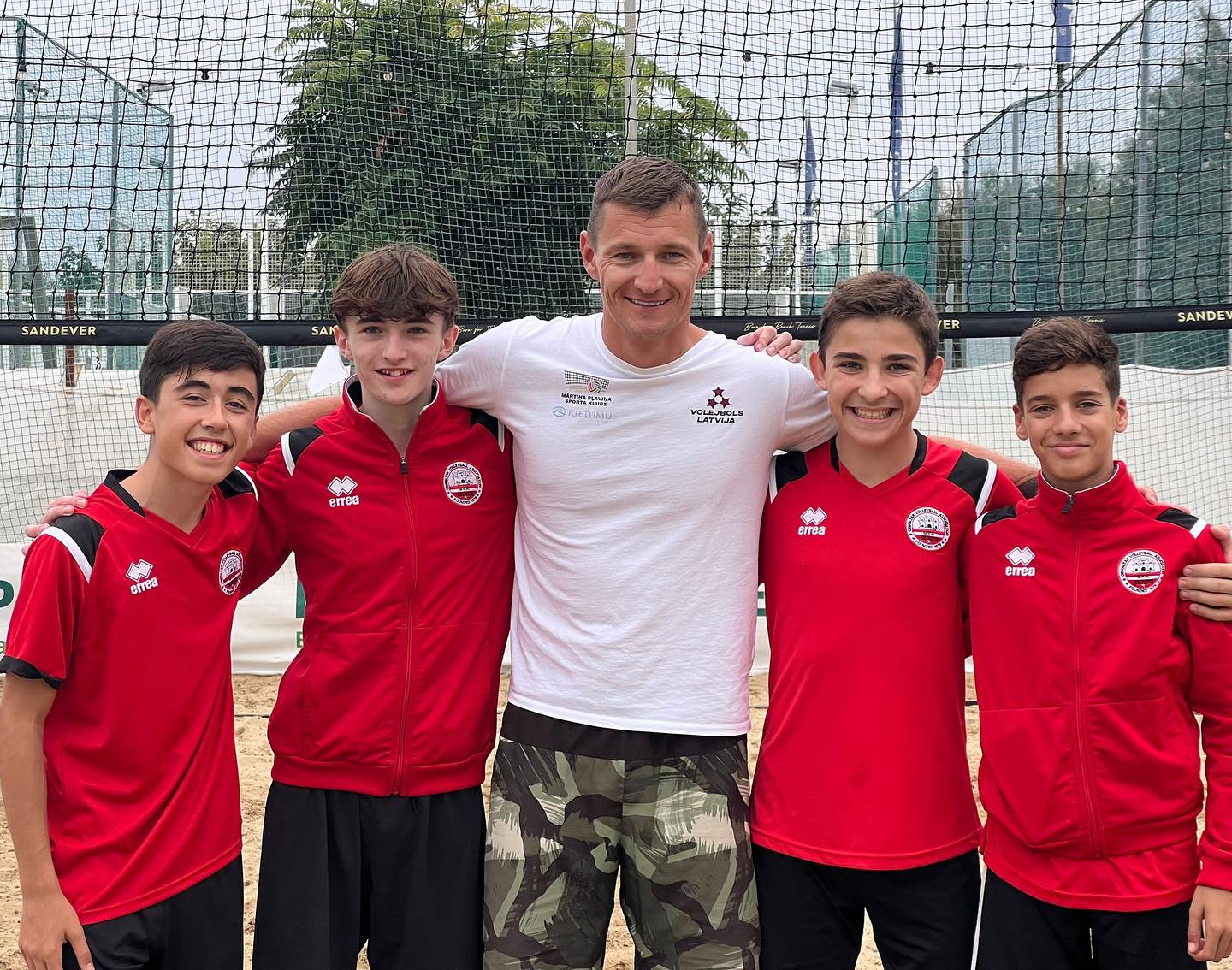 Los jóvenes jugadores gibraltareños posan con el olímpico letón Mārtiņš Pļaviņš en Italia