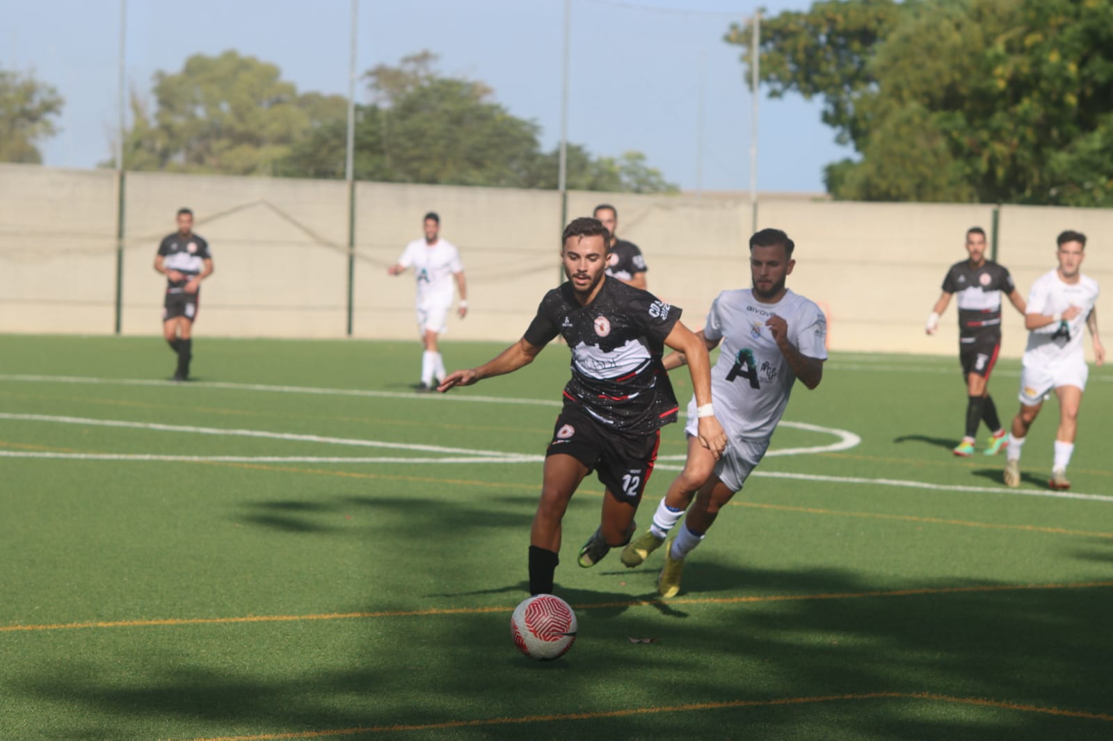 El jugador barreño del CD San Roque, Álex González, lleva la pelota ante el acoso de un jugador del Arcos CF/Foto: Juan Molina