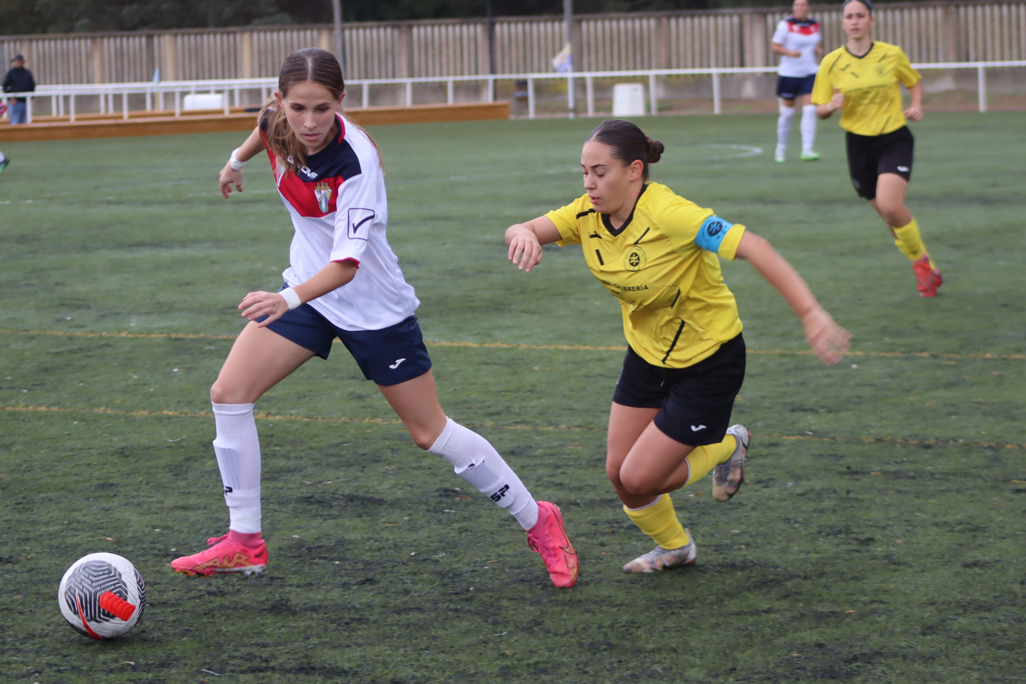 La jugadora del Algeciras CF, Miryam Cana, busca el pase a una compañera ante la presión de Elena Fernández, capitana del CD Juventud Chiclana/Foto: Axel S.C.