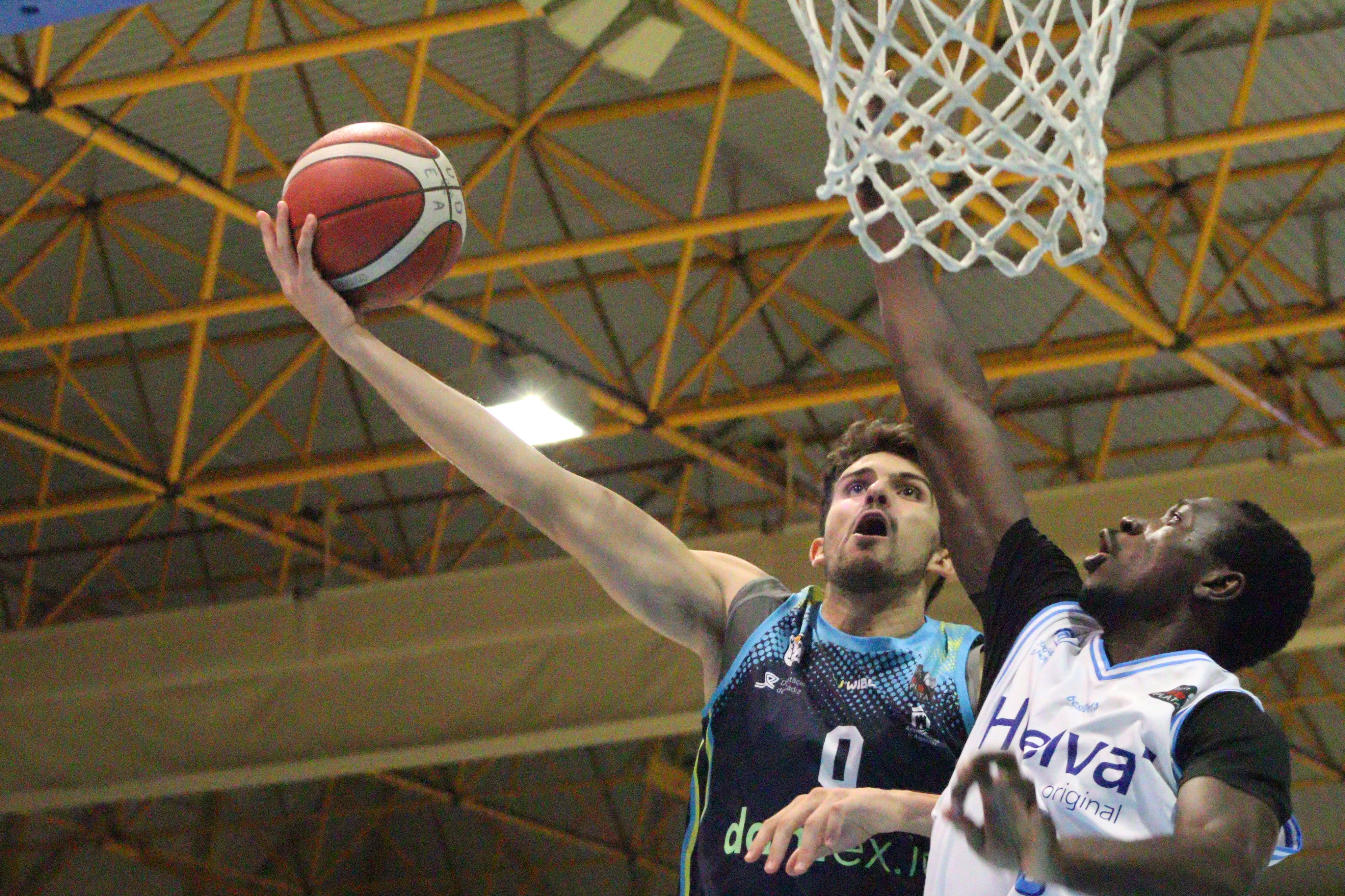 Sergio Cecilia, de UDEA, trata de encestar ante la presencia de Soulemane Chabi Yo, del Ciudad de Huelva/Foto: Axel S.C.