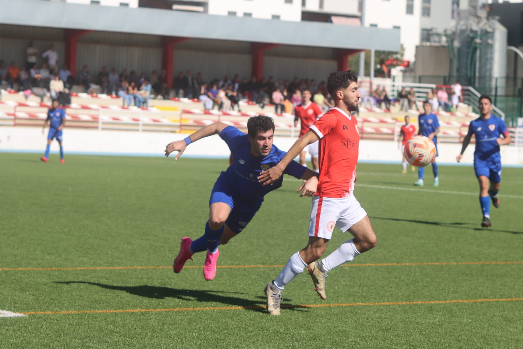 El jugador del CD San Roque, Manu Tamarit, controla el balón ante un futbolista del Trebujena CF/Foto: Juan Molina