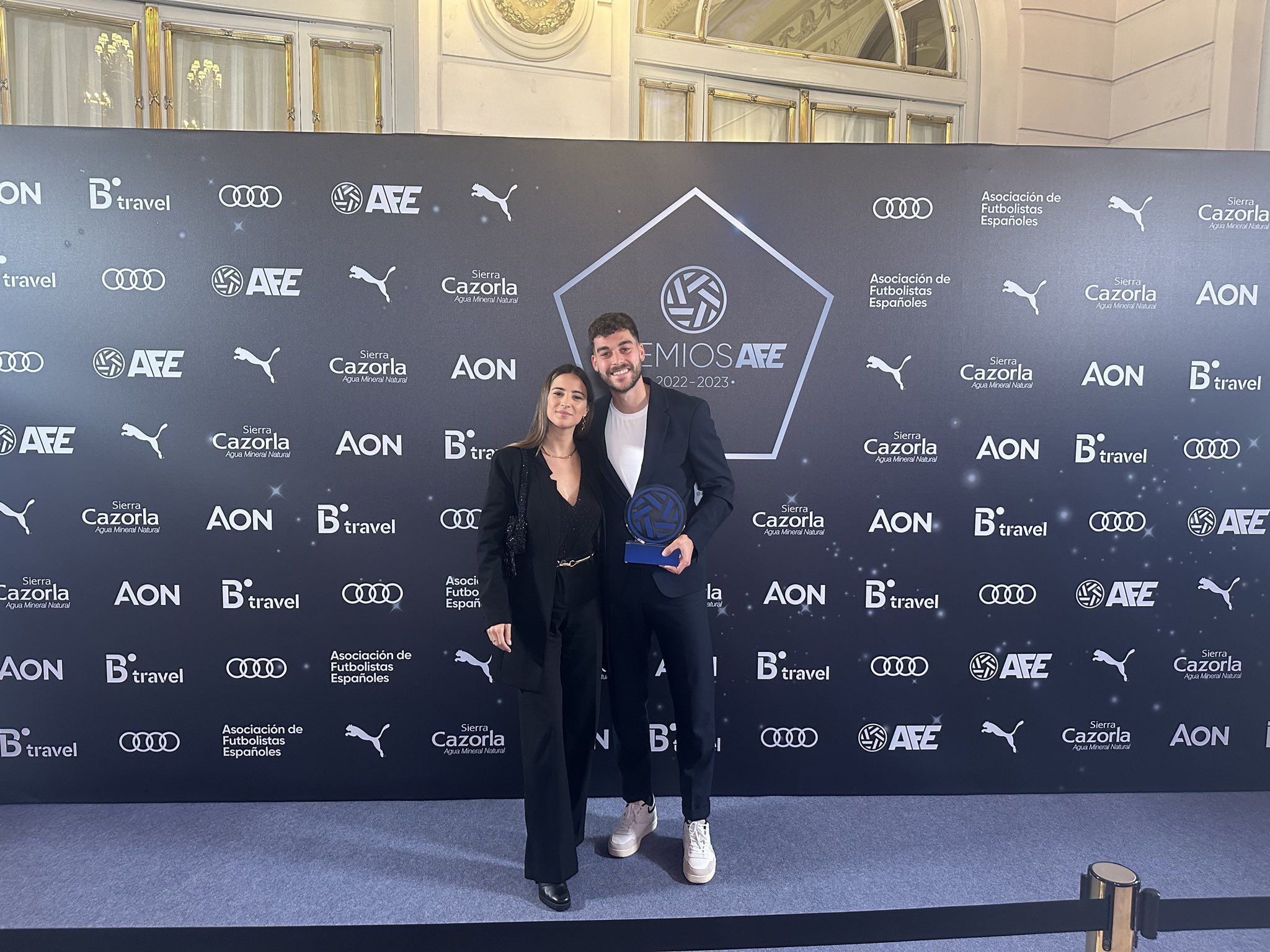 El ex balono Luis Alcalde posa con su pareja y el trofeo al mejor jugador del Grupo IV de la Segunda RFEF
