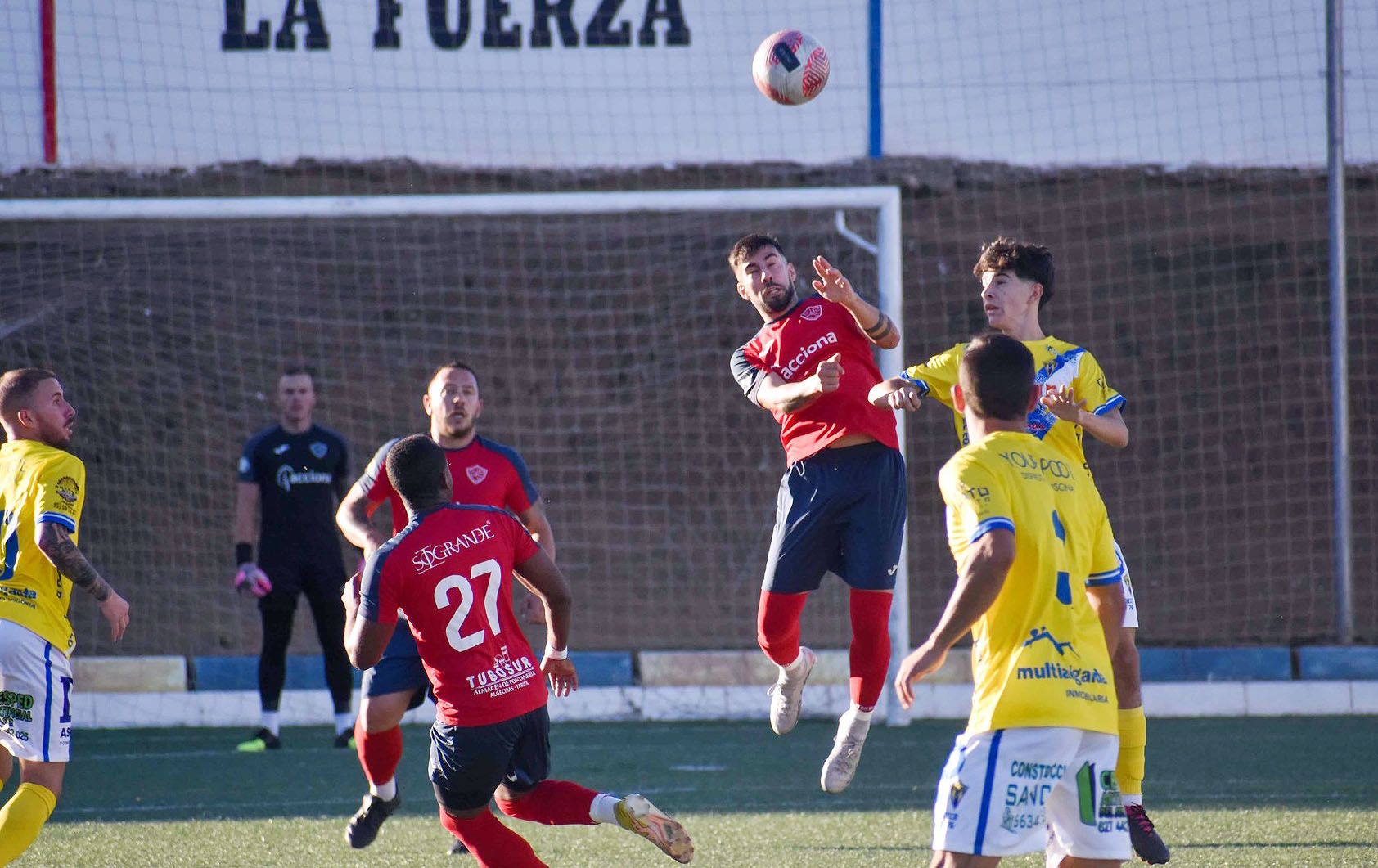 Álvaro García, del CD Guadiaro, salta con un jugador del Rayo Sanluqueño/Foto: CD Guadiaro