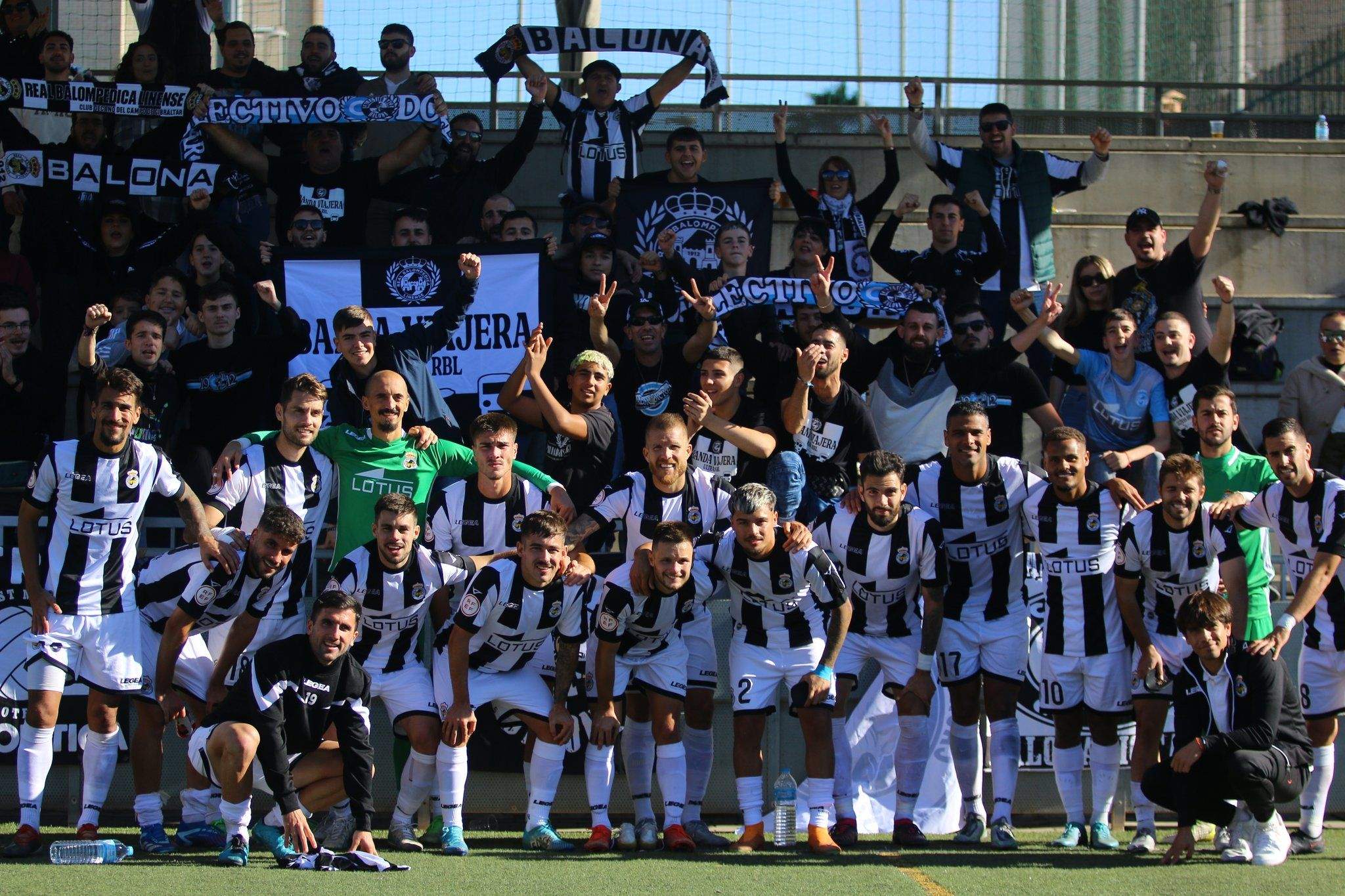 Los jugadores de la Real Balompédica Linense posan con los aficionados blanquinegros tras la victoria en El Palo/Foto: @RBL1912