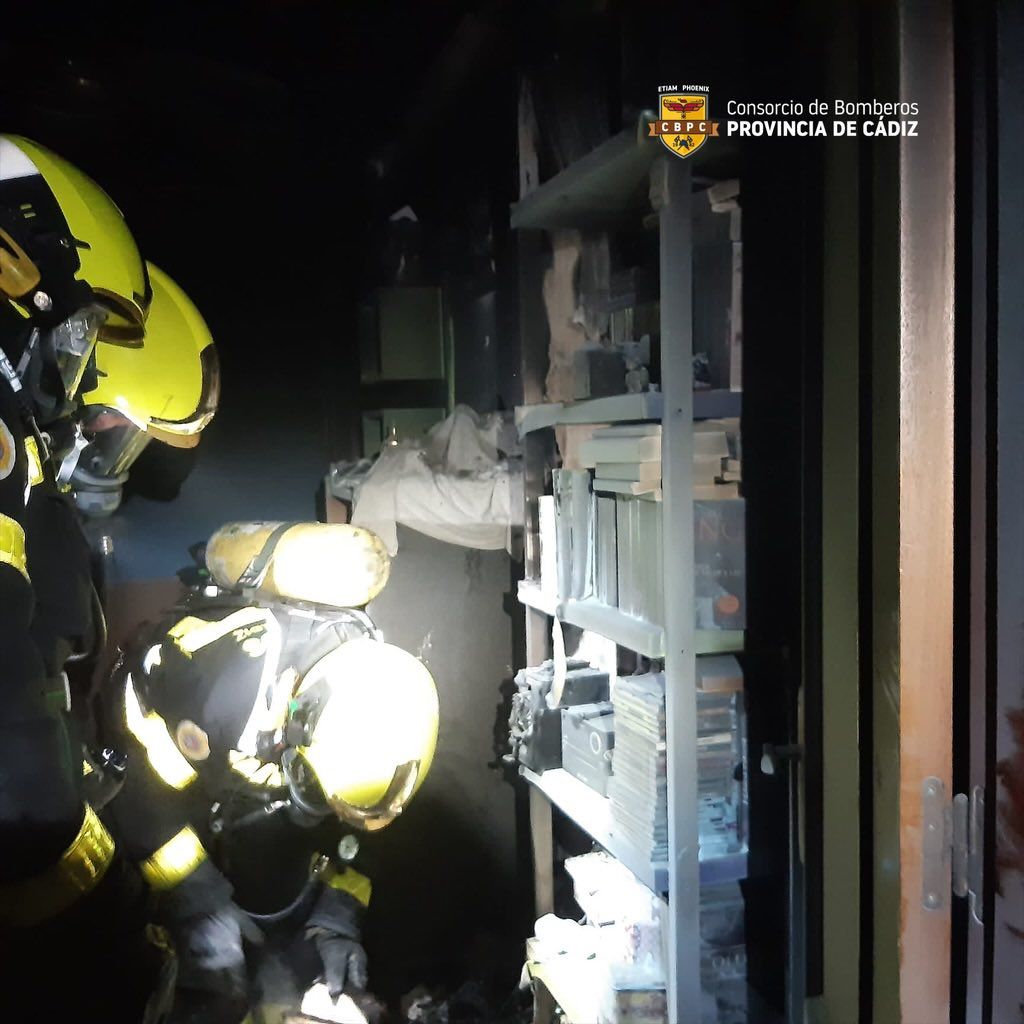 Bomberos actúan en el interior de la vivienda afectada.