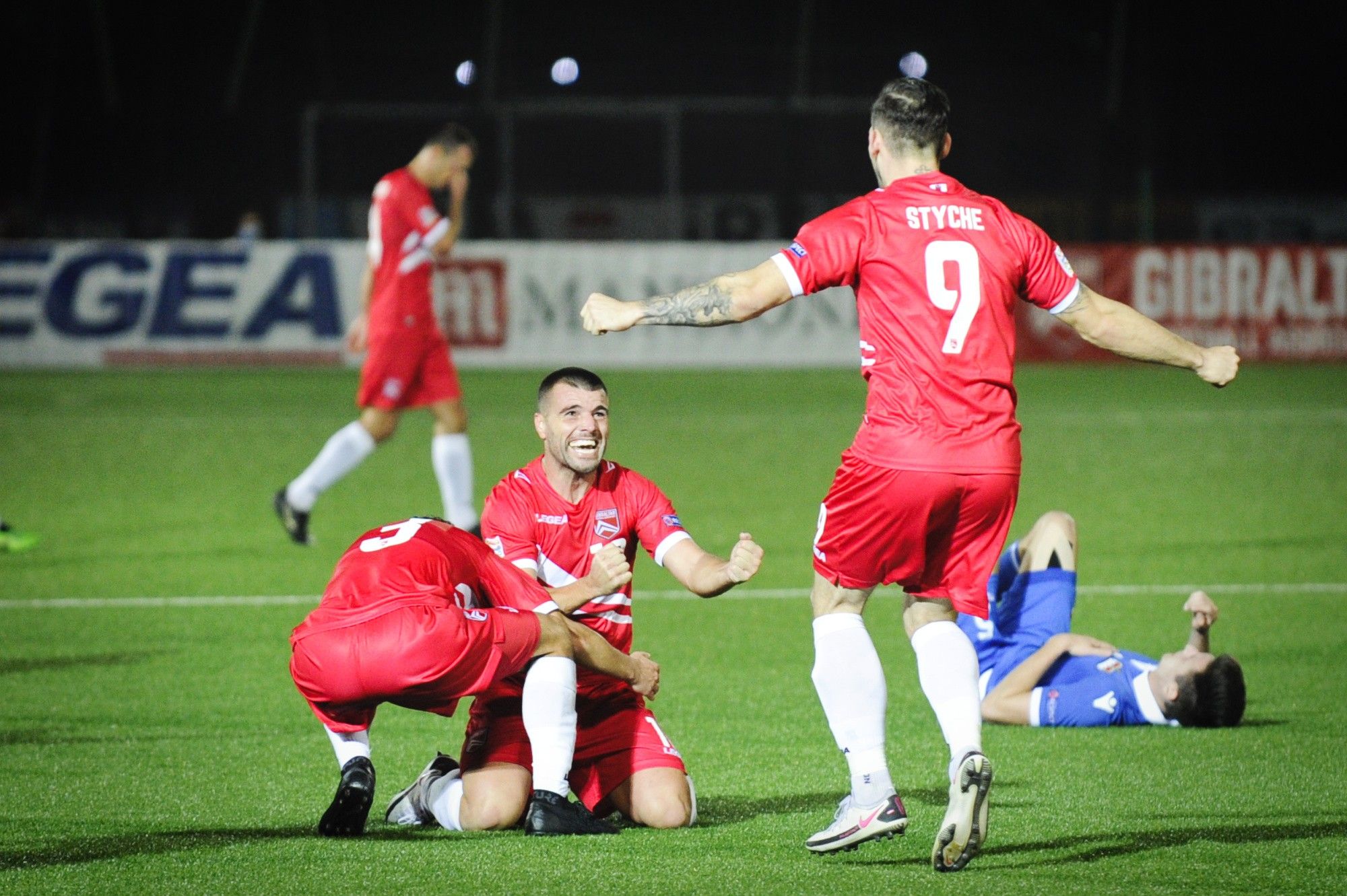 Liam Walker, de rodillas, festeja con un compañero y Reece Styche el ascenso a la Liga C de la Nations League en la campaña 22/23