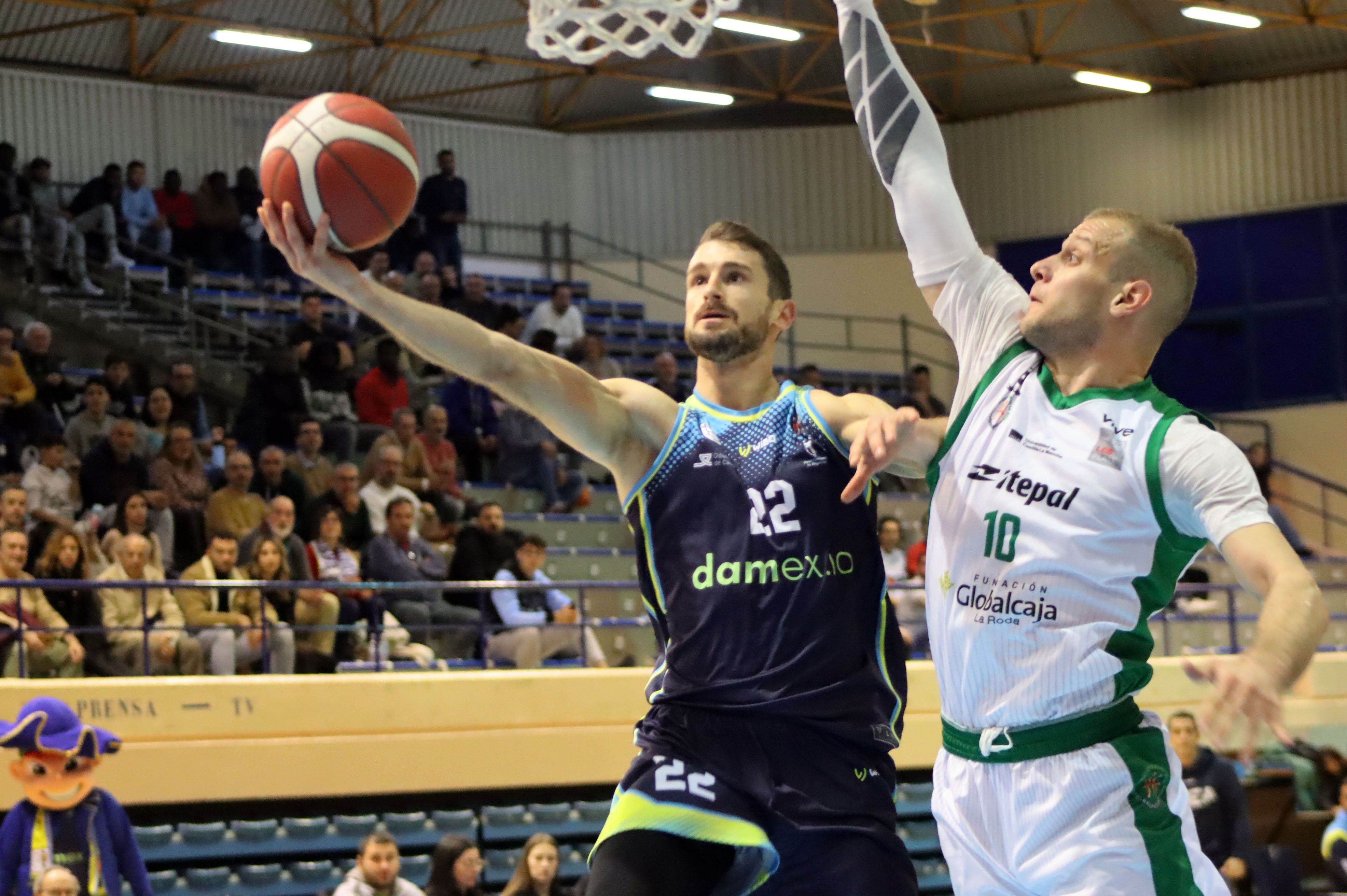 Berni García intenta la canasta ante Matija Bilalović en el partido donde UDEA 'aleja el descenso' con una contundente victoria frente a La Roda (89-65)