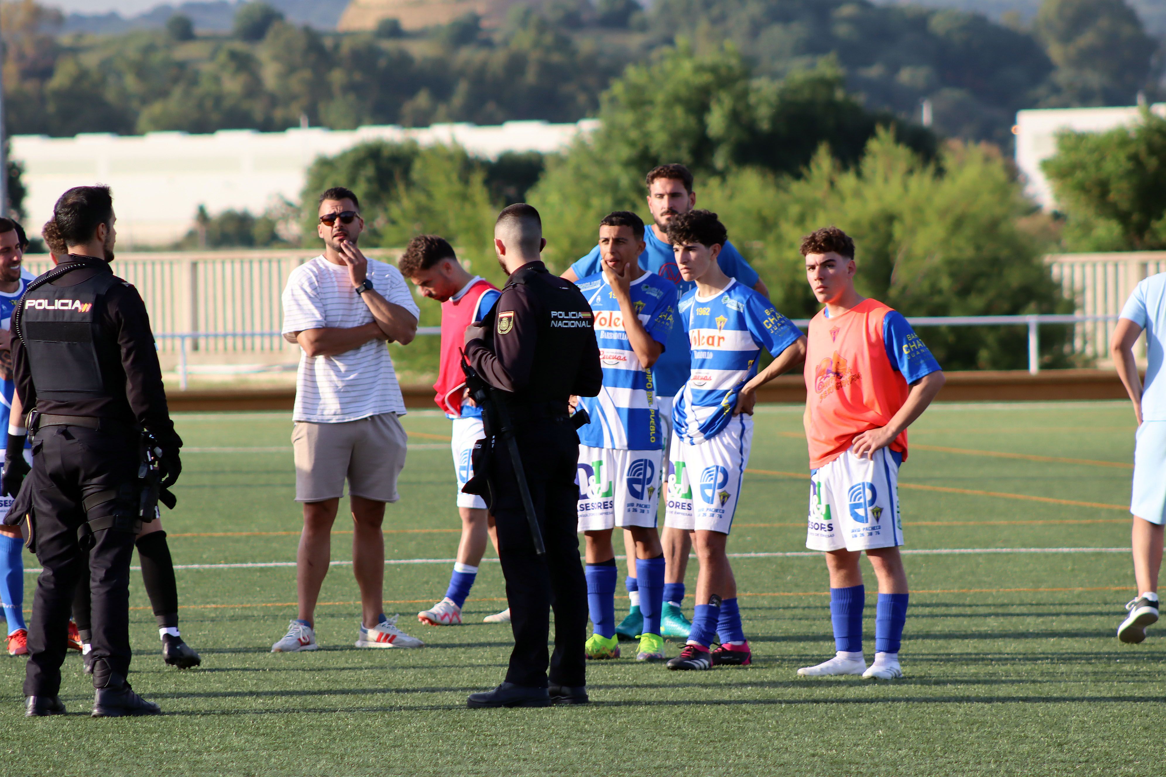 Agentes de la Policía Nacional junto a los jugadores del CD Rayo Sanluqueño