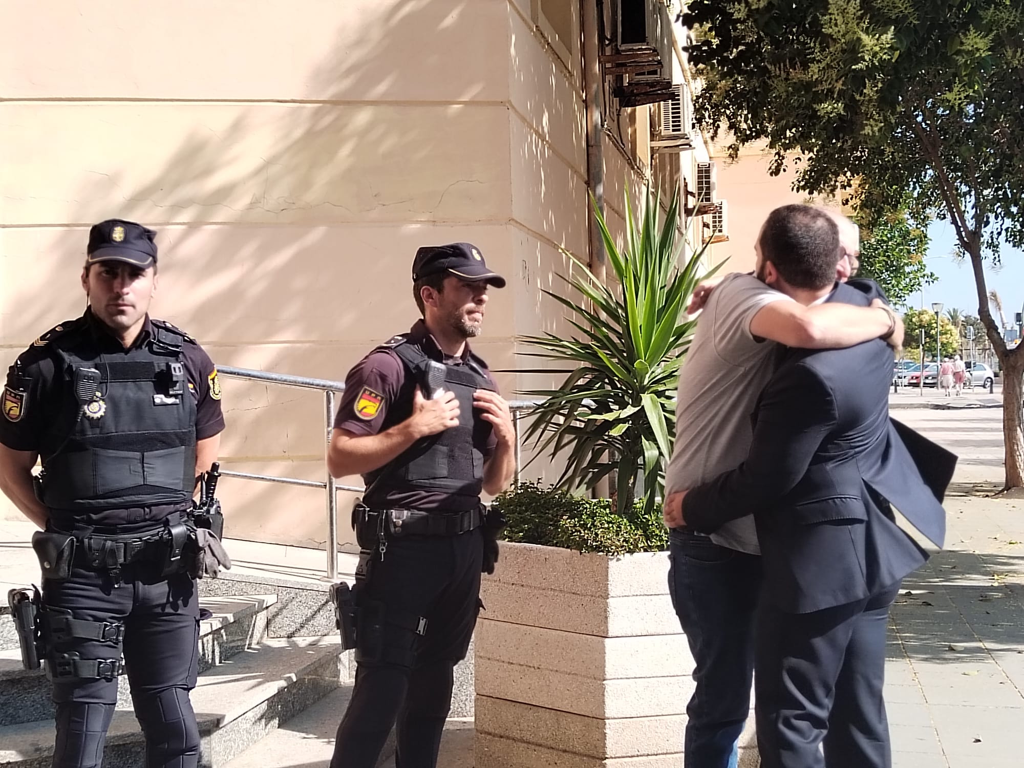 El inspector se abraza con compañeros a su llegada a la Audiencia.
