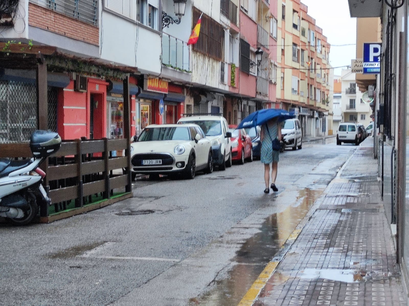 Una mujer se refugia de la lluvia con su paraguas en el centro de La Línea. Foto: S. D. 