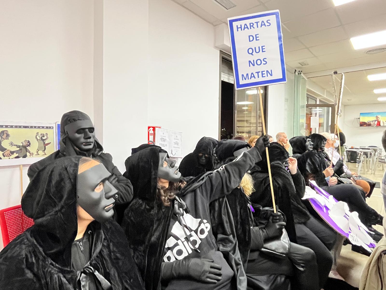 Una mujer con el rostro oculto en una máscara muestra un cartel que reza: Estamos hartas de que nos maten. Foto: F. M. Titular: Dos nuevos episodios de violencia machista en la comarca recuerdan este 25-N que aún queda mucho por hacer. 