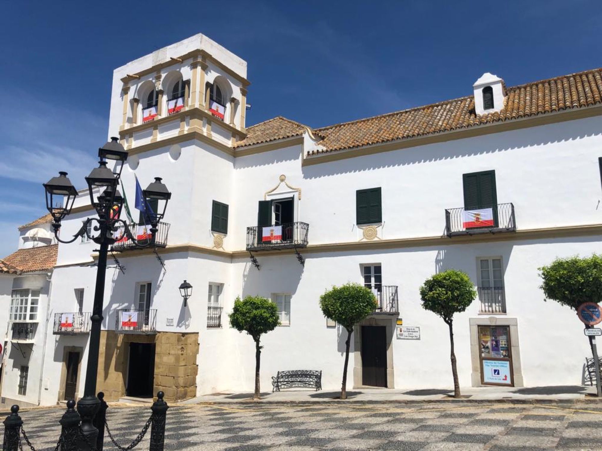 El Ayuntamiento de San Roque entrega banderas para engalanar balcones por el Día de la Ciudad.