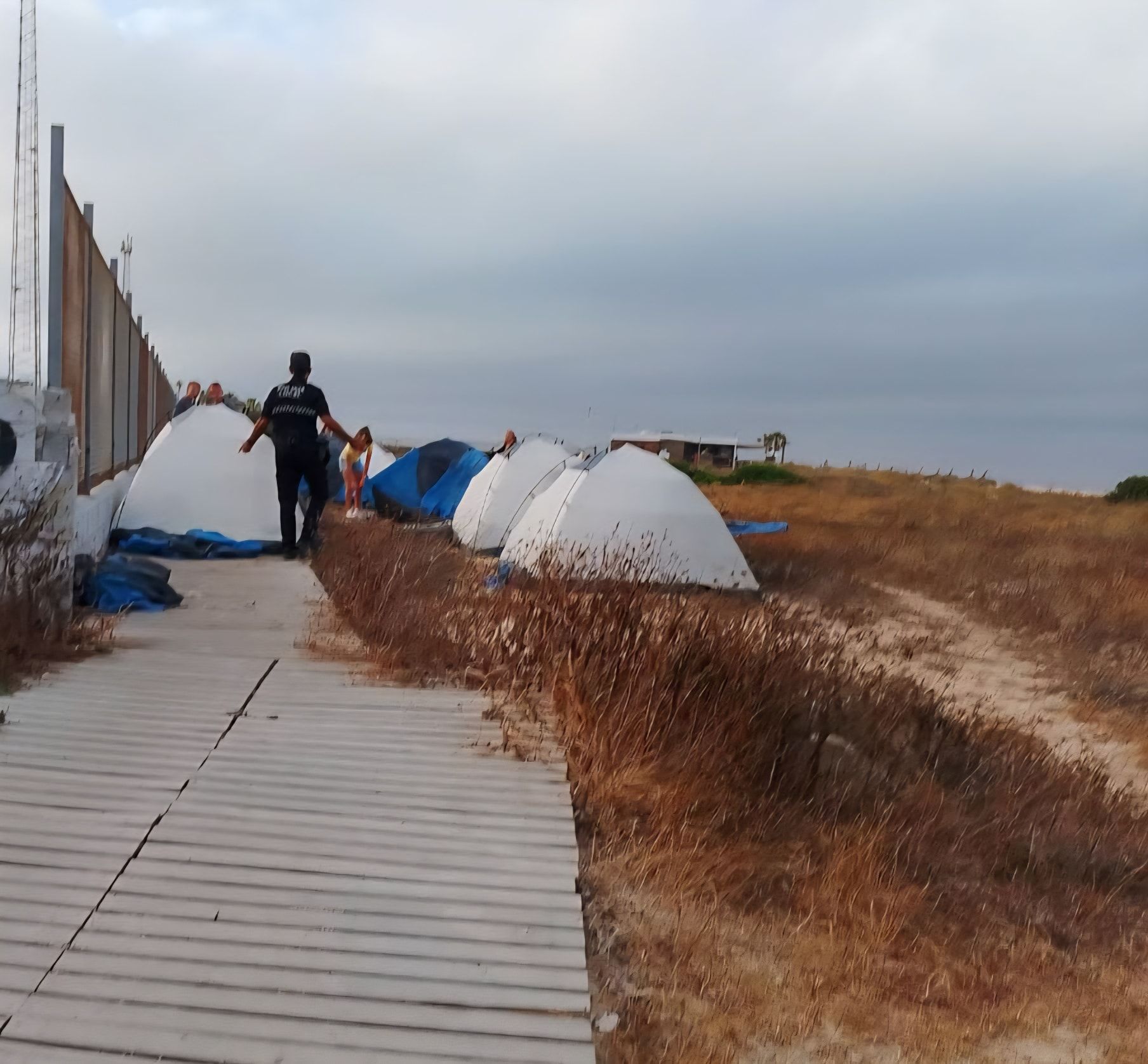 La Policía Local de Tarifa retira un camping improvisado en una pasarela de acceso a la playa