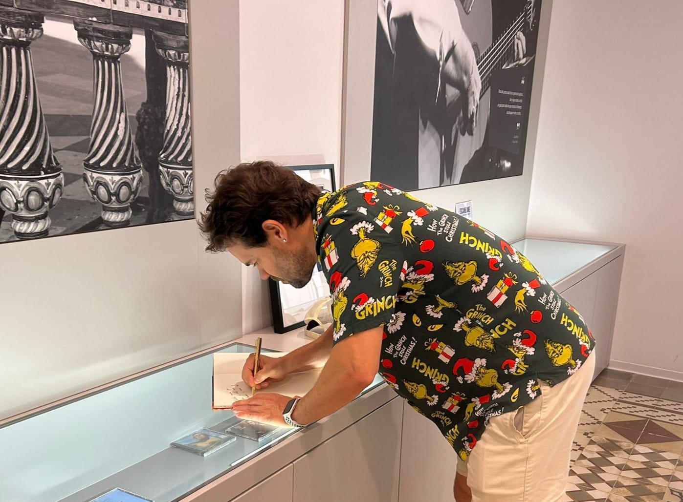 El artista Juan Dávila firma en el Libro de Honor del Centro Paco de Lucía tras visitar su exposición.