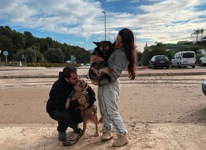Alba García, junto a un compañero y dos de los perros rescatados.