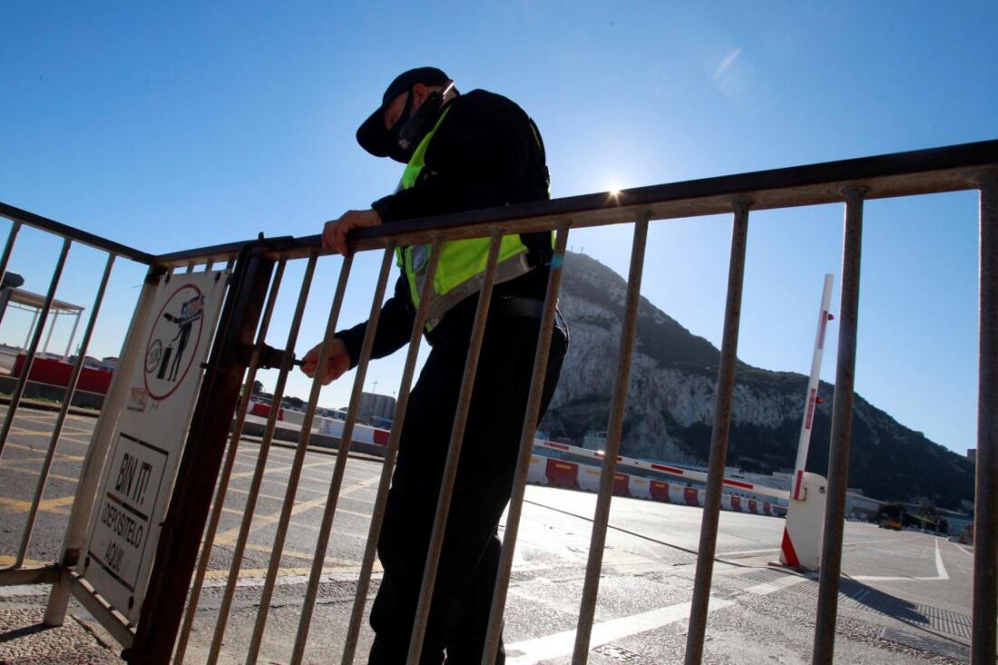 Archivo. Un agente de la policía de Gibraltar cierra la cancela que da acceso a cruzar el aeropuerto a los peatones, por la llegada inminente de un avión al aeropuerto de Gibraltar, en diciembre de 2020. EFE/A.Carrasco Ragel.