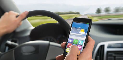 Close-up Of A Person's Hand Using Cellphone While Driving A Car